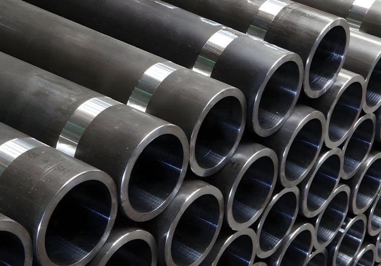 Conjunto de tuberías de acero en proceso de revisión de calidad, destacando la alta durabilidad y precisión de fabricación de MMTubería.
