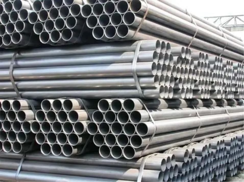 Apilamiento de tuberías de acero en grandes cantidades en un almacén, demostrando la capacidad logística y el amplio inventario