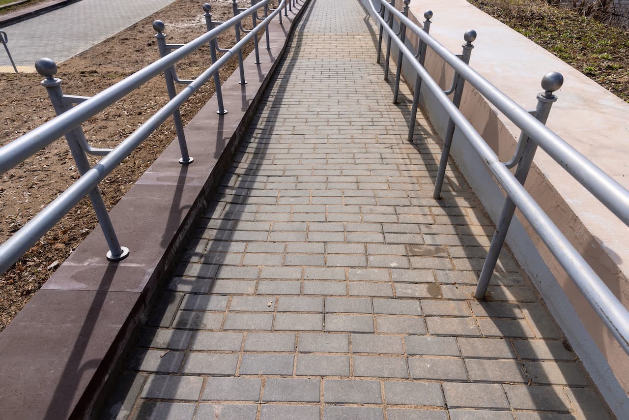 Camino peatonal con barandales de acero, destacando el uso de productos de MMTubería en construcciones urbanas, con un enfoque en durabilidad y calidad.