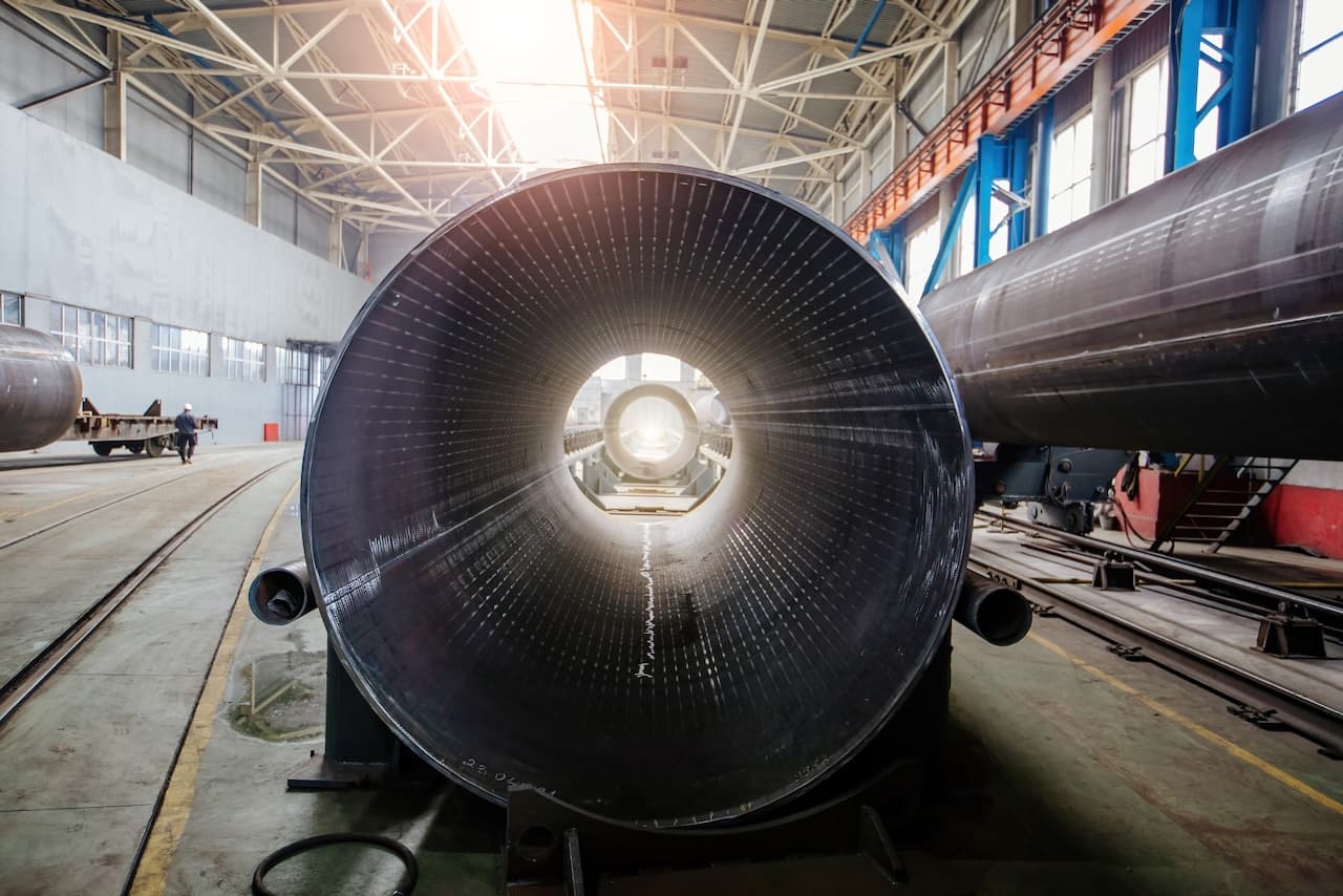 Vista interna de una tubería de acero gigante en la planta de MMTubería, mostrando el proceso de fabricación de alta calidad y la precisión en la creación de productos duraderos para distribución a nivel nacional.