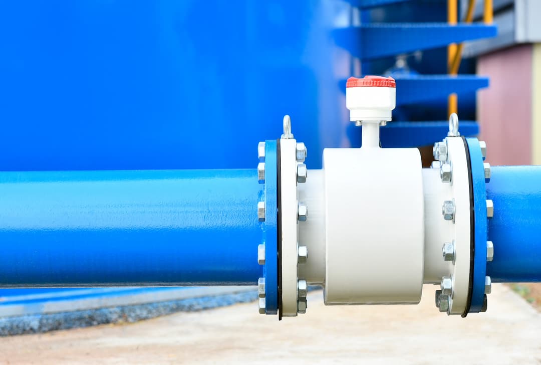 Válvula de acero industrial conectada a una tubería, reflejando la precisión en la fabricación y la calidad en la infraestructura ofrecida por MMTubería.