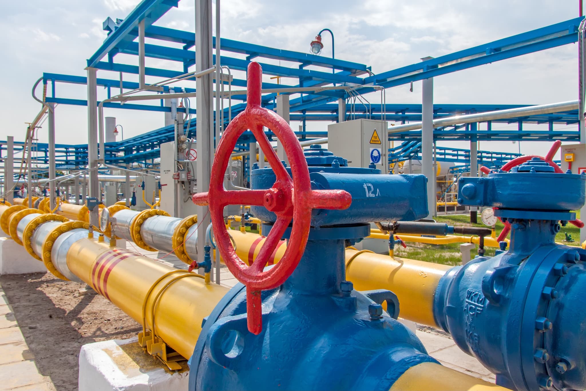 Válvula industrial en tubería de acero conectada a infraestructura de distribución, representando el proceso de alta calidad y durabilidad en la fabricación de MMTubería.