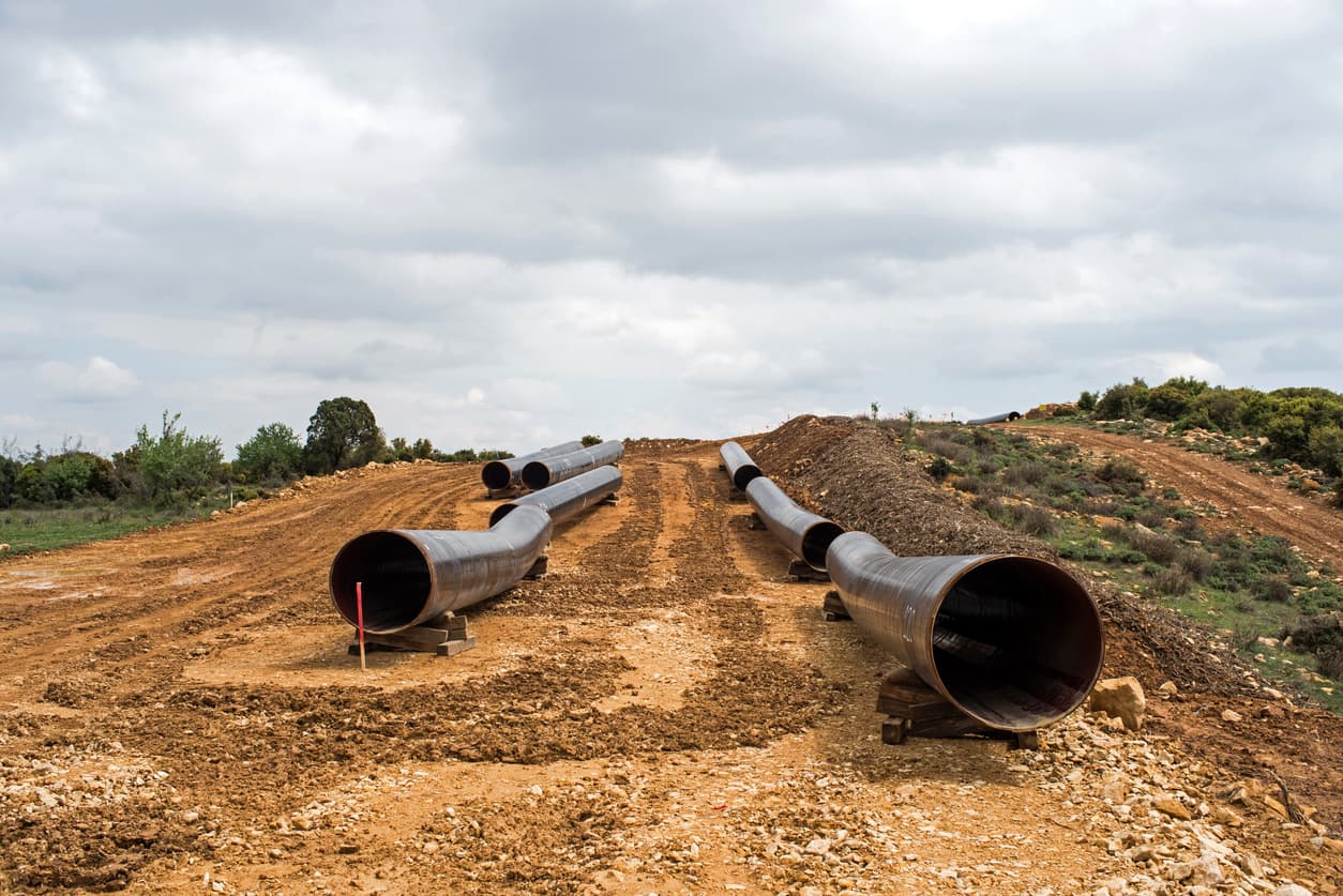 Tuberías de acero helicoidal colocadas en un terreno para su instalación, destacando el proceso de construcción de infraestructura a gran escala con productos de alta calidad de MMTubería.