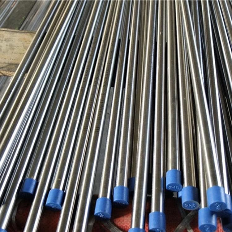 Detalle de tuberías de acero almacenadas verticalmente, mostrando su brillo y calidad, listas para ser utilizadas en proyectos de construcción e ingeniería.