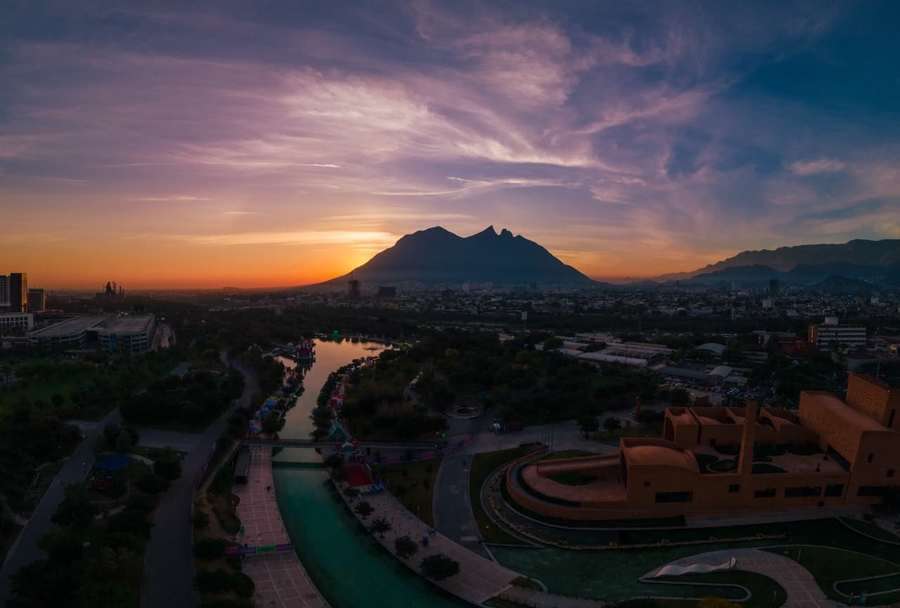 Vista panorámica de la ciudad al atardecer con una montaña en el fondo, simbolizando el alcance nacional de MMTubería y su contribución en proyectos de infraestructura a lo largo de México.