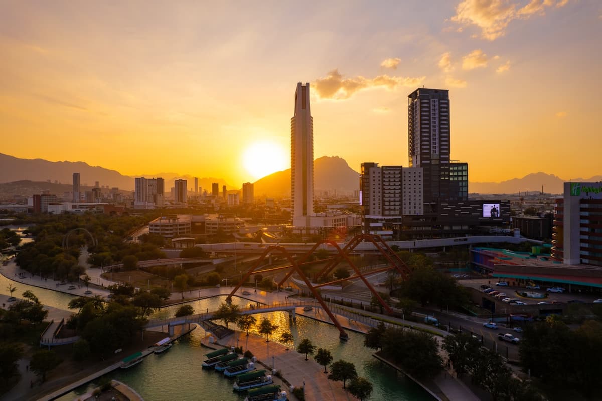 Vista de la ciudad al atardecer con un rascacielos destacado, representando el alcance nacional de MMTubería en la distribución de tuberías de acero para grandes proyectos urbanos en México.