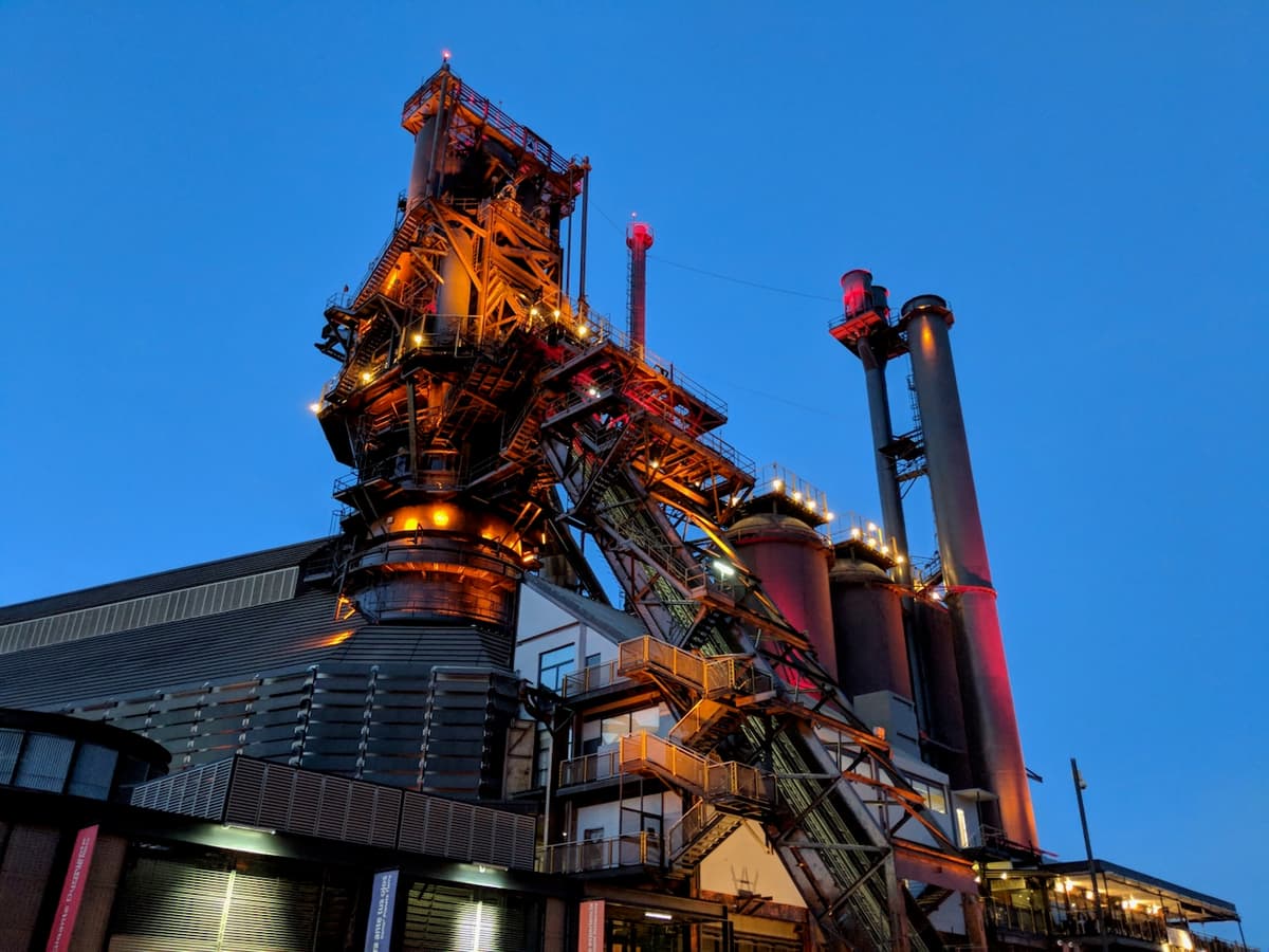 Instalación industrial iluminada al anochecer, reflejando la contribución de MMTubería en proyectos industriales que requieren soluciones de tuberías de acero resistentes y de alta calidad.