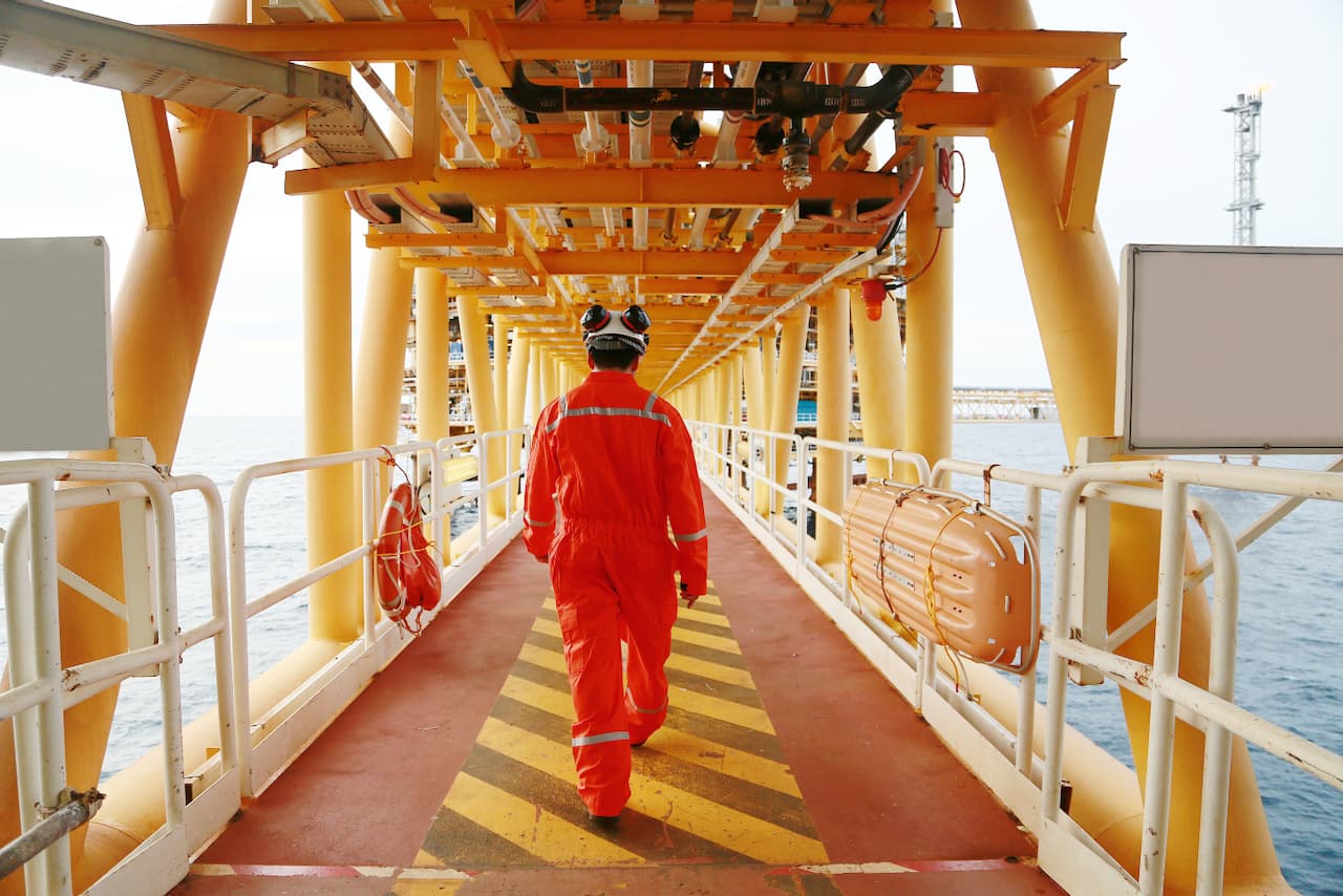 Trabajador industrial en una plataforma marina, destacando el compromiso de MMTubería con la seguridad y durabilidad de sus tuberías de acero en ambientes extremos.